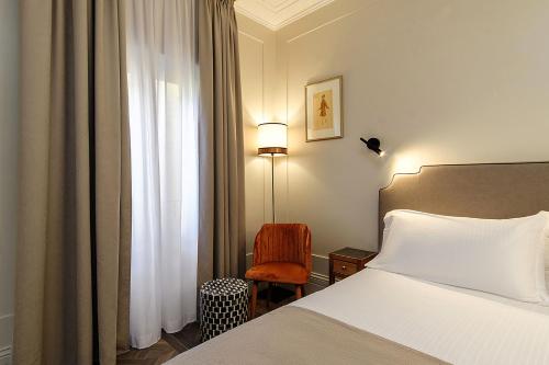 a hotel room with a bed and a chair at Hotel Smeraldo in Rome