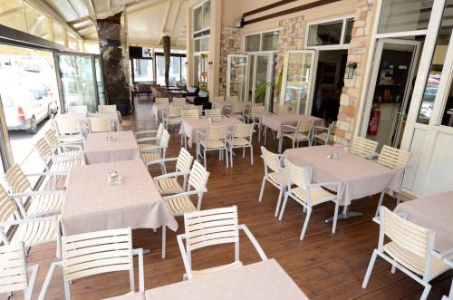 a row of tables and chairs in a restaurant at Hotel Epavli in Nea Kalikratia