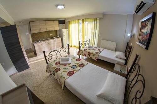 サルティにあるSky Hotelのベッド2台とキッチンが備わる小さな客室です。