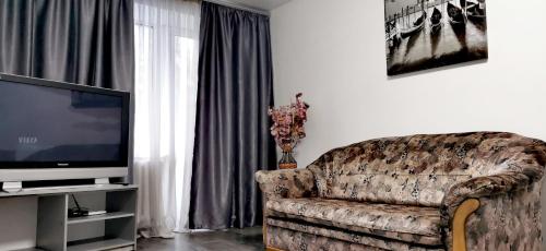 - un salon avec un canapé et une télévision dans l'établissement Квартира на проспекте Поля 127, à Dnipro