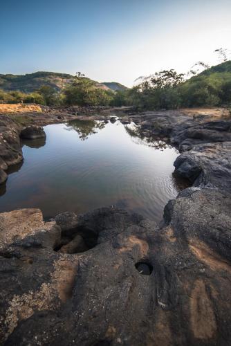 a small pool of water on a rocky field at Mastiff Grand La Villae in Lonavala