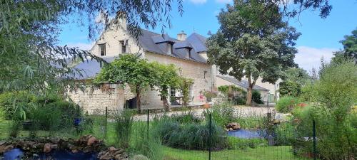 uma casa antiga com um jardim em frente em La Magnanerie em Savigny-en-véron