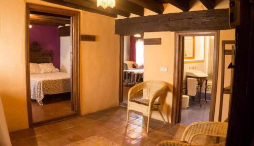 a room with a mirror and a bedroom with a bed at Posada El Canchal in Arenas de San Pedro