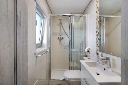 a bathroom with a shower and a toilet and a sink at Numar Residence Villa Z in Manta Rota