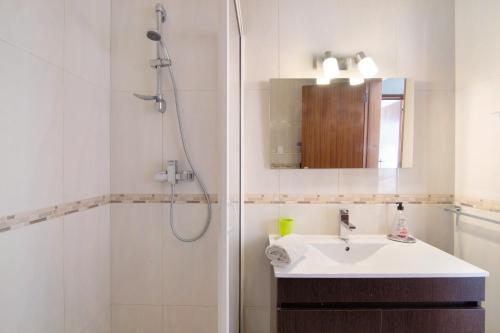 y baño blanco con lavabo y ducha. en T2 Balaia, en Albufeira