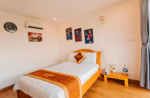 a small bedroom with a bed and a table at Window Homestay in Kon Tum