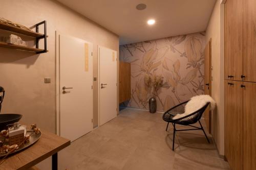 a hallway with a chair and a wall with a painting at Hotel Lion in Modřice