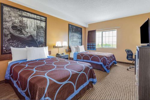 ein Hotelzimmer mit 2 Betten und einem Flachbild-TV in der Unterkunft Super 8 by Wyndham Fort Dodge IA in Fort Dodge