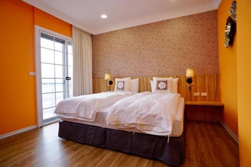 1 dormitorio con 1 cama grande y paredes de color naranja en Dafu Qiandai Manor, en Zhuangwei