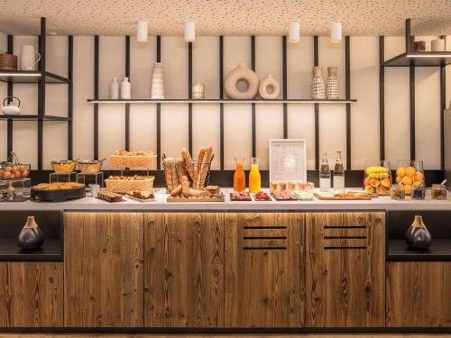 a counter with a buffet of food on it at Mercure Chambéry Centre in Chambéry
