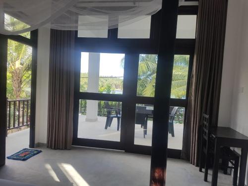 a room with a large window with a view of a patio at Waves Hiri Sea View in Hiriketiya