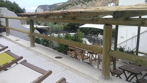 a balcony with chairs and tables on a roof at Casa Baia Luna in Ponza