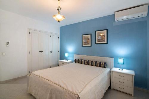 アルマカオ・デ・ペラにあるApartamento Nautilusの青いベッドルーム(ベッド1台、ナイトスタンド2台付)