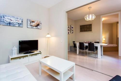 sala de estar con TV y mesa con sillas en Stay U-nique Apartments Floridablanca II, en Barcelona
