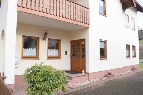 une maison avec une porte et des fenêtres en bois dans l'établissement OB Ferienwohnung Sensbachtal, à Untersensbach