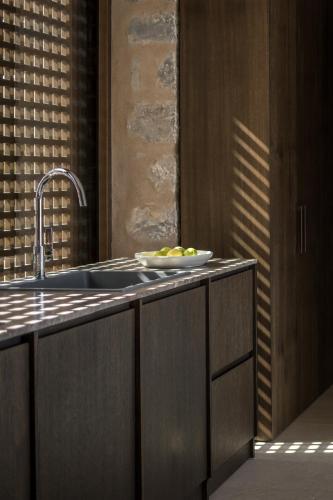 a kitchen with a sink and a bowl of fruit on the counter at Monolithoi Villas in Piyí