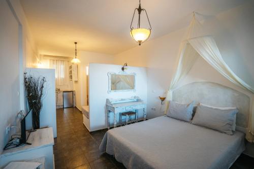 a bedroom with a white bed and a table at Cape Napos in Faros