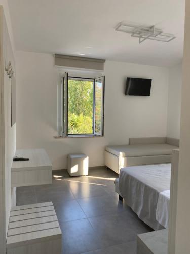 ein weißes Schlafzimmer mit einem Bett und einem Fenster in der Unterkunft Area Sosta Camper V&B in Marina di Montenero