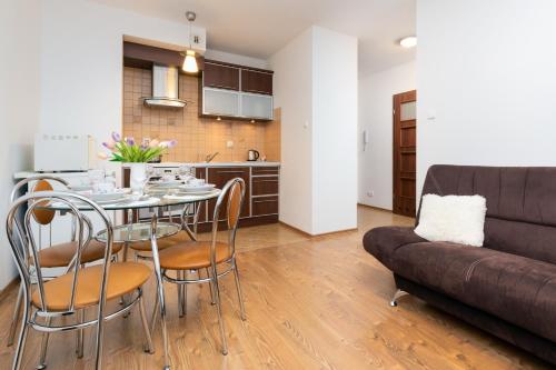 a living room with a table and a couch at Karawela Gdańsk Apartments by Renters in Gdańsk