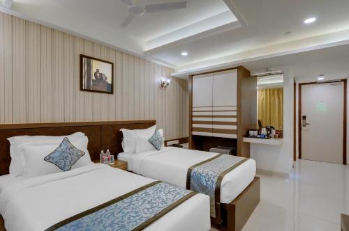 a hotel room with two beds and a bathroom at Click Collection Jaipur in Jaipur