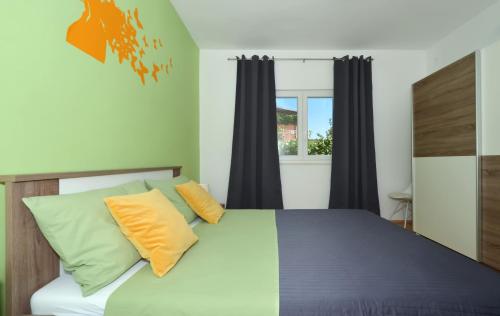 1 dormitorio con 1 cama con almohadas amarillas y grises en Apartments Nina, en Vinišće