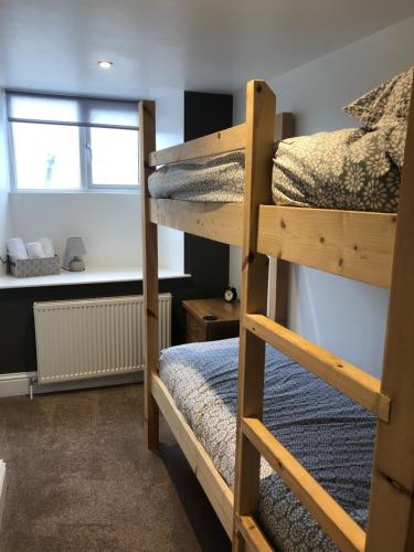 1 Schlafzimmer mit 2 Etagenbetten und einem Schreibtisch in der Unterkunft The Prince of Wales Bed and Breakfast in Princetown