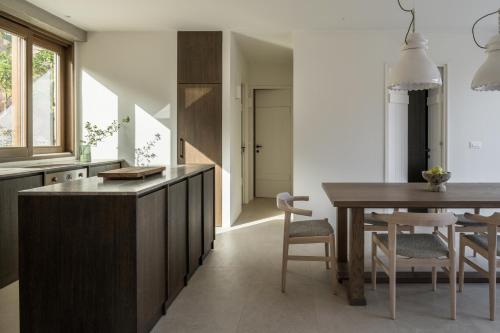 a kitchen with a table and a dining room at Monolithoi Villas in Piyí