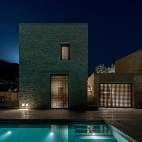 a house with a swimming pool at night at Monolithoi Villas in Piyí