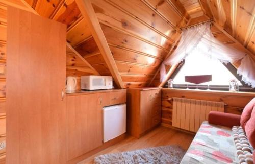 a small kitchen in a wooden cabin with a window at Willa u Samków in Zakopane