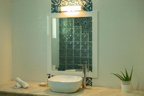 a bathroom with a sink and a mirror at Athara's Apartment in Praslin