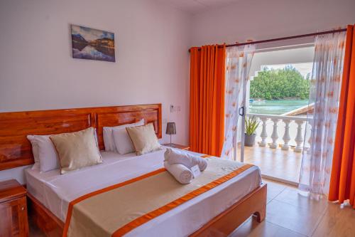 a bedroom with a large bed and a large window at Athara's Apartment in Anse Possession