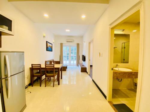 a kitchen and dining room with a table and a refrigerator at Pearl Service Apartment in Ho Chi Minh City