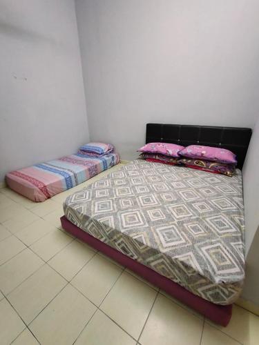 two beds are sitting in a room at Rosdan Homestay in Bachok