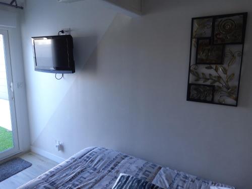 1 dormitorio con TV en la esquina de una pared en Chambre d'hôtes en Lunel