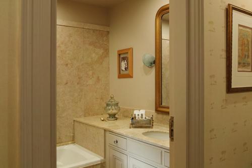 a bathroom with a tub and a sink and a mirror at Albergo Hotel in Beirut