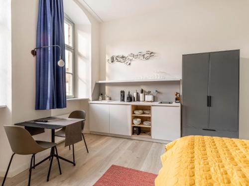 um quarto com uma secretária, uma mesa e uma cozinha em limehome Bamberg Maximiliansplatz em Bamberg