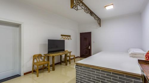 a kitchen with a table and a tv in a room at Floral Hotel Jixian Heping Heyuan Jizhou Karst Cave Ares Valley in Ershilipu