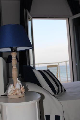 a lamp sitting on a table next to a bed at Hotel Nautilus in Cagliari
