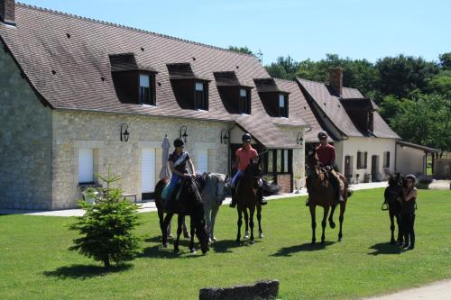a group of people riding horses in front of a house at Chambres et Table d'Hôtes Les Machetières in Langeais