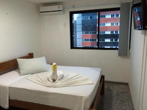 um quarto com uma cama com um pássaro sentado nela em Ametista Flat em Maceió