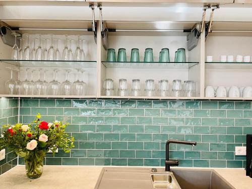 a kitchen with a sink and green subway tiles at Cottage Wilkenburg - das luxuriöse und idyllische Ferienhaus in Hemmingen