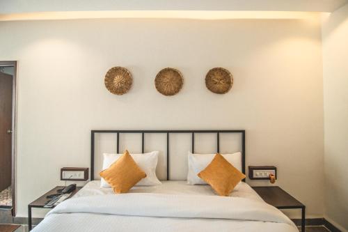 a bedroom with a bed with three plates on the wall at Amber Rooms in Porvorim
