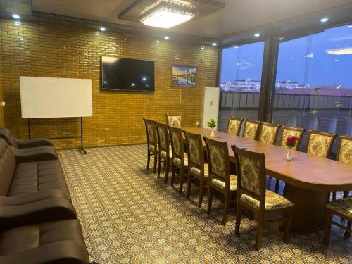 einen Konferenzraum mit einem Tisch, Stühlen und einem Whiteboard in der Unterkunft VOSTOK HOTEL in Buxoro