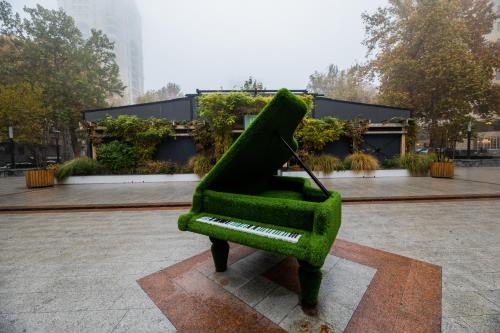 a green chair sitting in front of a building at Diamond Hotel Yerevan in Yerevan