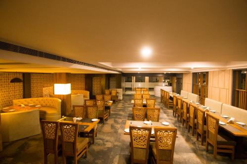 a restaurant with tables and chairs in a room at The River Front Resort in Sītāpur Mūāfi