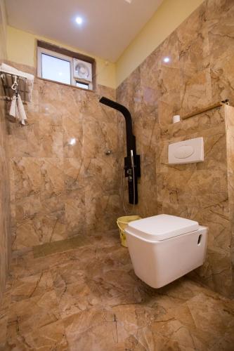 a bathroom with a toilet and a stone wall at The River Front Resort in Sītāpur Mūāfi