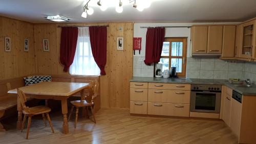 a kitchen with a wooden table and a dining room at Der Perweinhof in Donnersbachwald