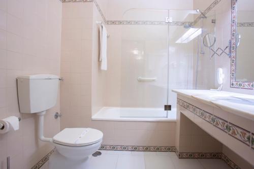a bathroom with a toilet and a shower and a sink at Hotel Casabela in Ferragudo