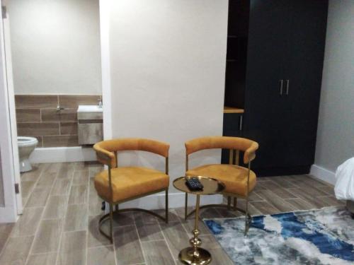 two chairs and a table in a bathroom at Sani Pass Manor Guest House in Himeville