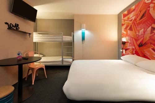 a room with a bed and a table and a bunk bed at Ibis Styles Toulouse Centre Canal du Midi in Toulouse